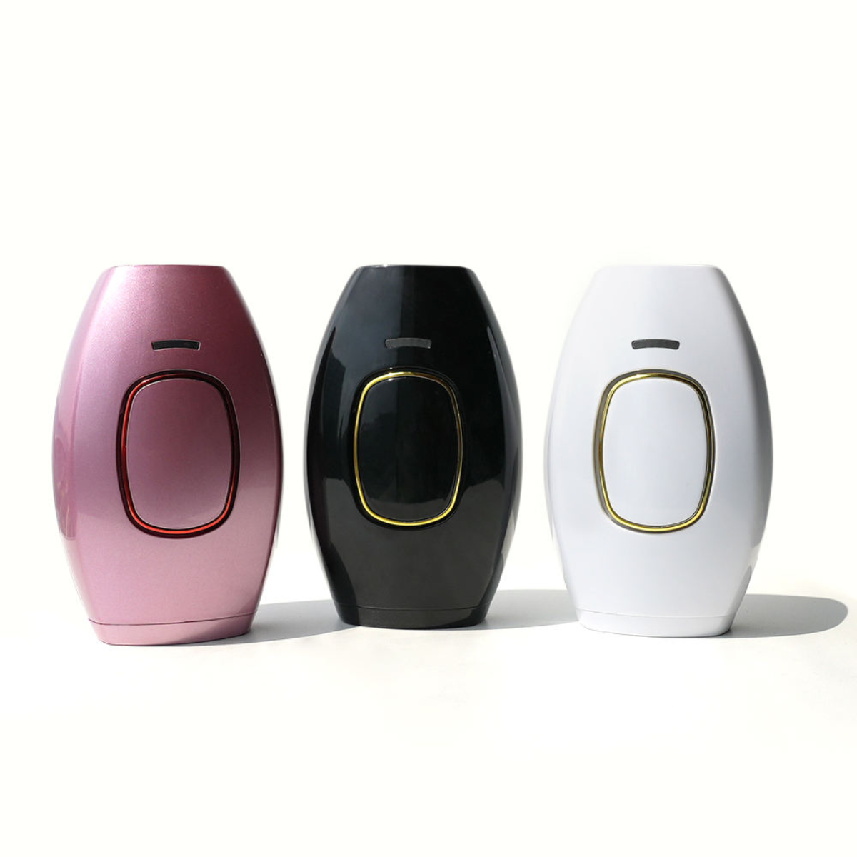 Three electronic devices in pink, black, and white on a white background